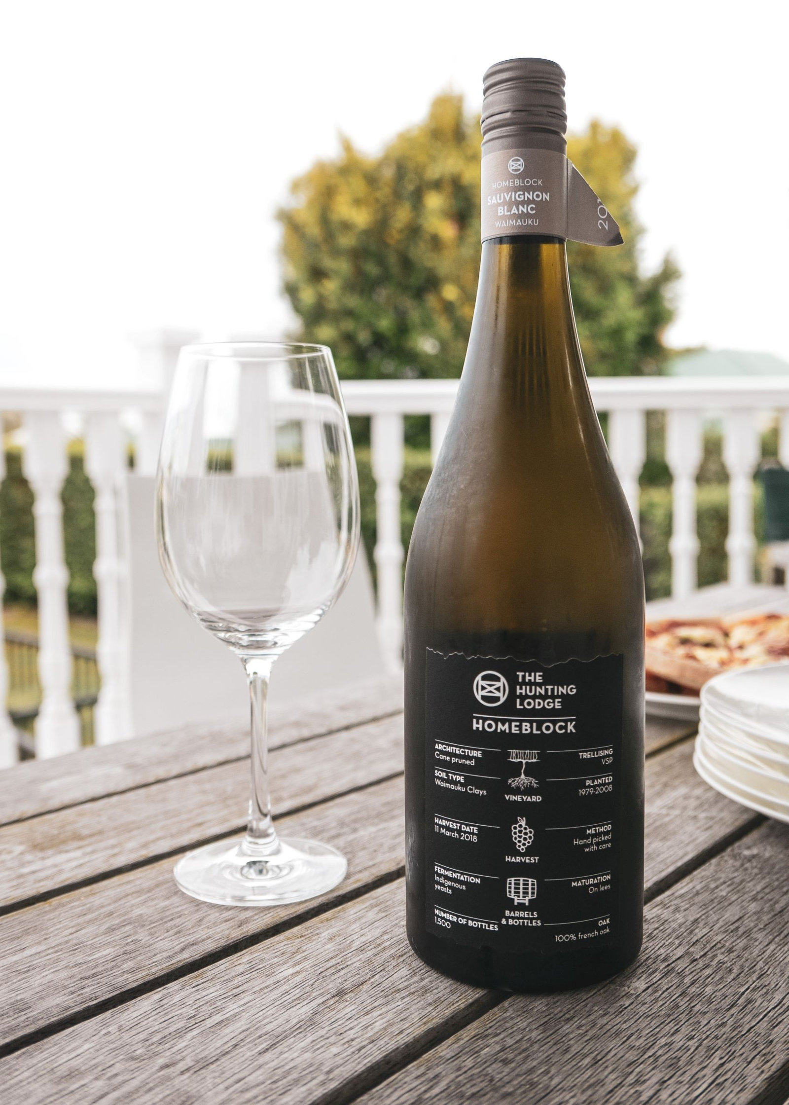 A bottle of The Hunting Lodge Homeblock wine next to a empty wine glass