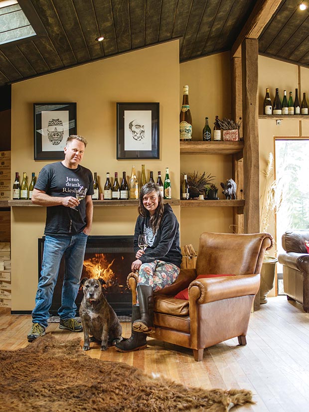 Duncan Forsyth and Anna Riederer infront of a fireplace with a dog