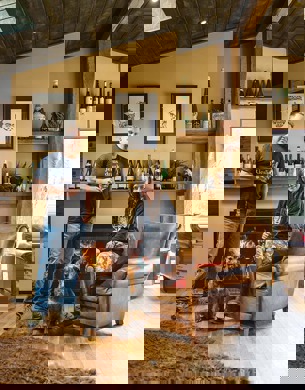 Duncan Forsyth and Anna Riederer infront of a fireplace with a dog