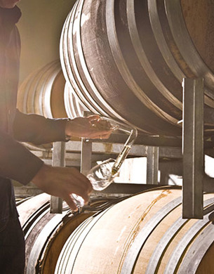 A person pouring wine from barrels at Villa Maria
