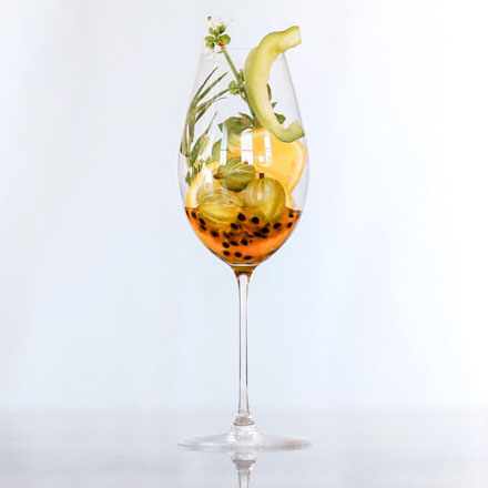 A wine glass filled with various fruit.
