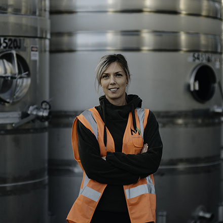 Alice rule standing infront of tanks in a winery