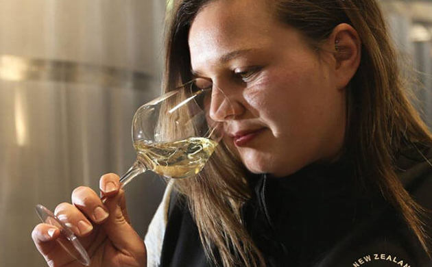 Women smelling a glass of wine.