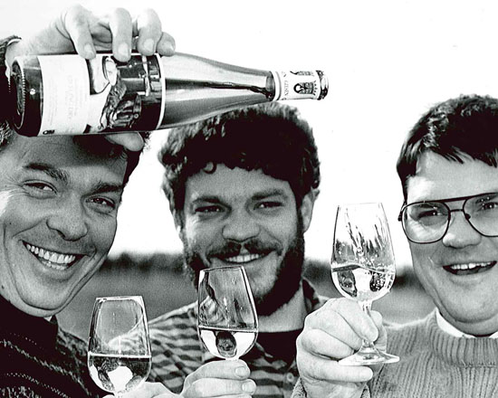 A black and white photo of the giesen brothers with wine glasses