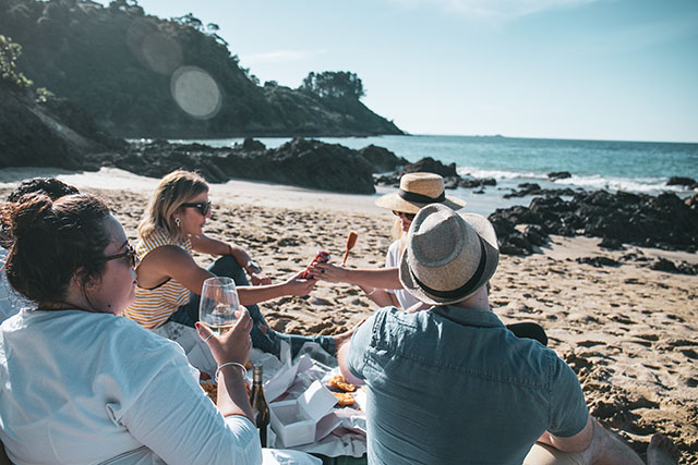 People on beach with glass of sauvignon blanc