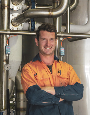 Ash Linklater standing in front of wine tank
